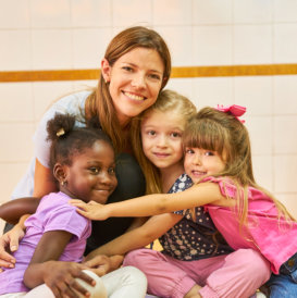 kids hugging their teacher